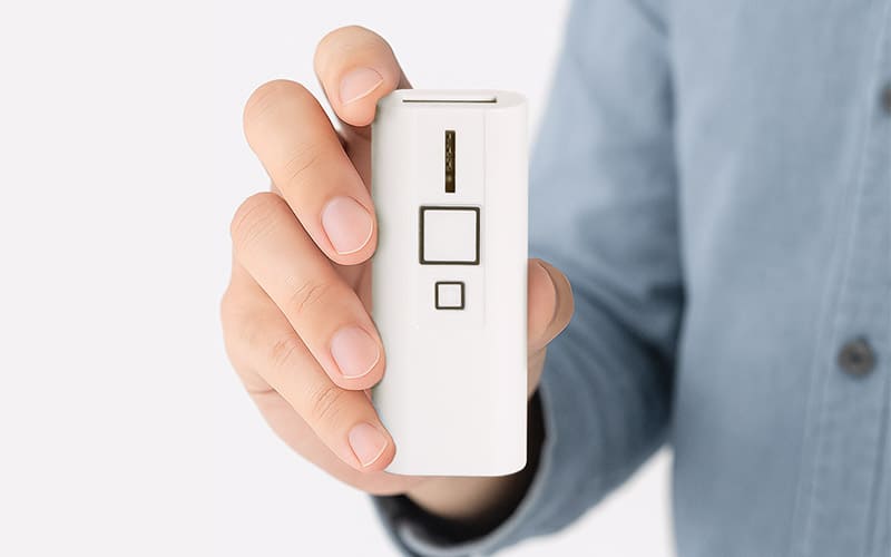 エフケイシステム QR対応 抗菌ワイヤレスバーコードリーダー BP-200C Plusを手に持った様子。