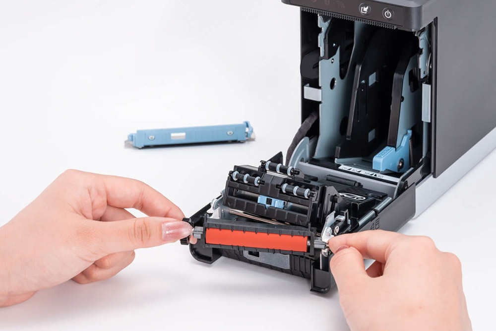 スター精密のサーマルラベルプリンターmC-Label2シリーズのメンテナンスをしているイメージ。プラテンローラーなどの消耗部品は、ユーザーが自分で交換できるようになっている。